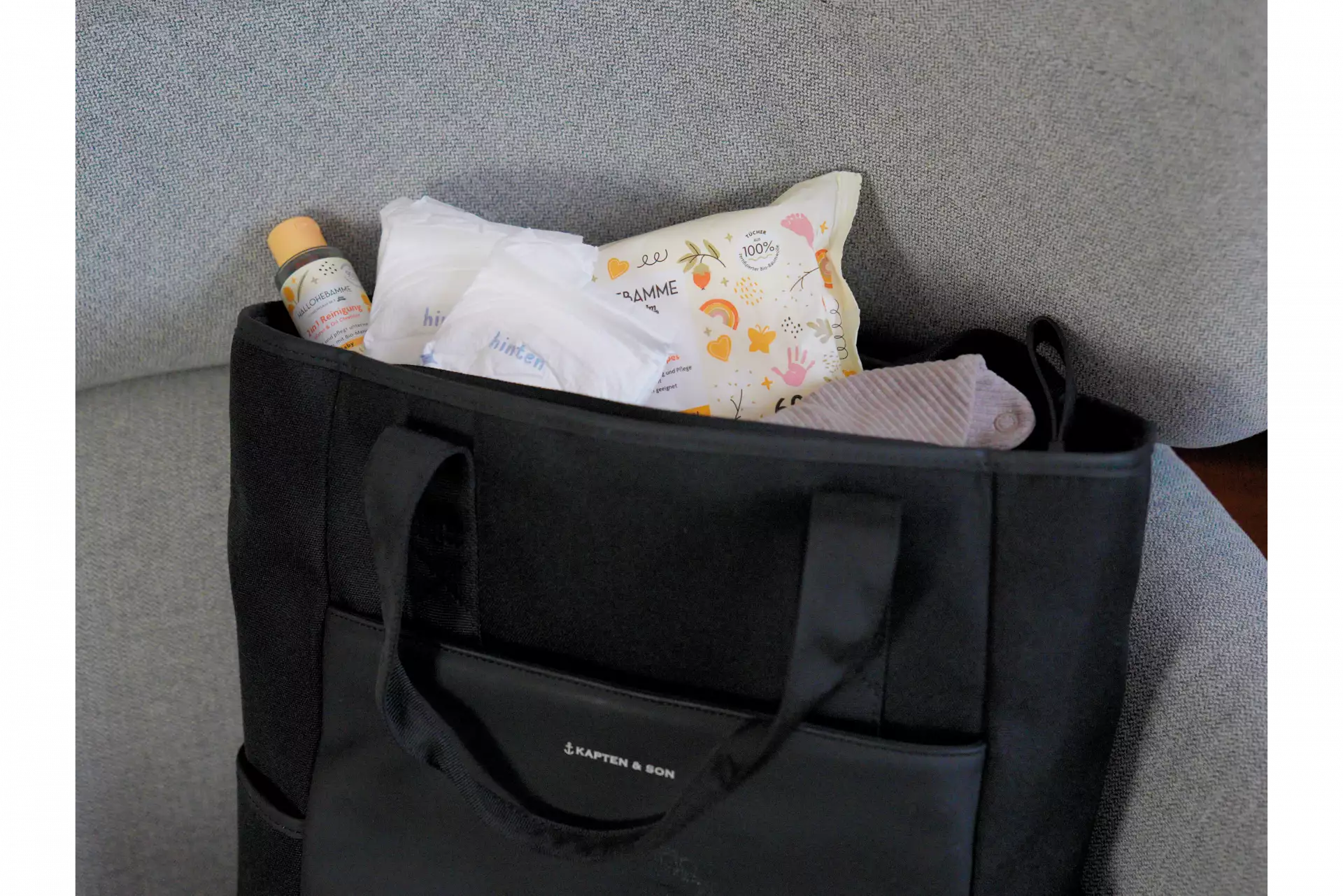 Ein Wickelrucksack, in dem sich Feuchttücher, ein Lätzchen, Windeln und eine sanfte Reinigung befinden.