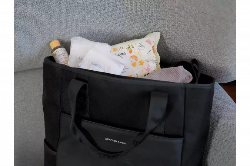 Ein Wickelrucksack, in dem sich Feuchttücher, ein Lätzchen, Windeln und eine sanfte Reinigung befinden.